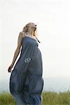 Young woman walking in meadow, bubbles floating around her