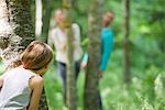 Girl hiding behind tree