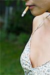 Woman wearing low cut top smoking, cropped