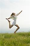 Young woman jumping in midair, side view