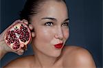Woman holding halved pomegranate