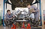 Mechanics working on car engine