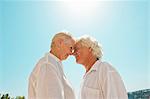 Older couple touching noses outdoors