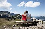 Couple sitting on bench on hilltop