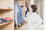 Woman picking clothes out of closet