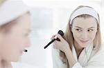 Smiling woman applying makeup