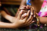 Mother and daughter holding hands in cafe