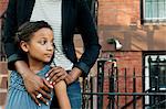 Girl standing with mother, looking away