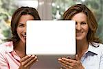 Two happy women holding laptop