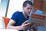 Young man reading newspaper