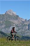 Boy Riding Bicycle in Mountains, Alps, France