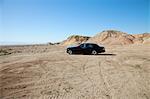 Rolls Royce car parked on unpaved road with tire tracks