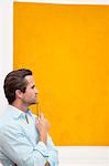 Close-up view of a thoughtful young man in front of wall painting