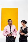 Two young executives in front of yellow painting