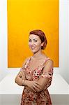 Half-length portrait of young woman in front of yellow painting