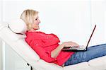 Femme senior sur chaise avec ordinateur portable