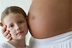 Girl listening to mother's pregnant belly