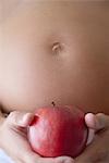 Schwangere Frau mit Apfel, zugeschnitten