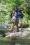 Couple standing by stream in woods