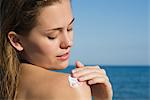 Woman applying sunscreen at the beach
