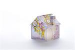 Model house folded with British pound banknote