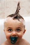 Petit garçon dans le bain avec les cheveux mouillés en langue mohawk, portrait
