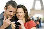 Couple regardant des photos sur l'appareil photo numérique