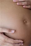 Pregnant woman touching her belly, cropped