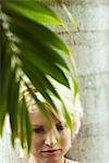 Woman relaxing under palm tree