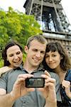 Amis qui posent pour une photo devant la tour Eiffel, Paris, France
