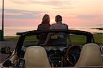 Couple admiring sunset in convertible