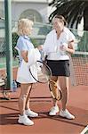 Older women talking on tennis court