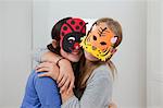 Smiling girls wearing colorful masks