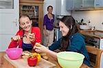 Girls peeling vegetables in kitchen