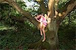 Young woman draped in an old oak tree