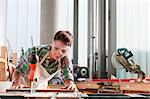 Carpenter using saw in workshop