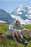 Couple assis sur le flanc de montagne, Oberland bernois, Suisse
