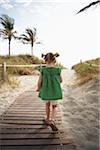 Petite fille se promener sur la promenade de la plage