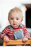 Baby boy leaning on chair