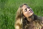 Young woman relaxing in field of grass