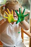 Kleines Mädchen mit Farbe auf ihre Hände