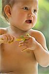 Baby holding paintbrush, portrait