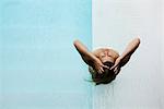 Woman in wading pool, head back, hands in hair