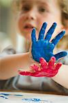 Little boy with hands covered in paint