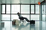 Businessman sitting in empty office with boxes on floor