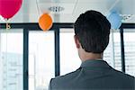 Businessman in room with balloons