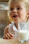 Little girl enjoying glass of milk