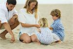 Famille jouant dans le sable à la plage