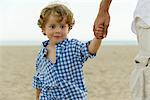 Kleinen jungen Vaters Hand hält, am Strand, zugeschnitten