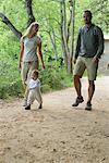 Parents hiking in woods with toddler